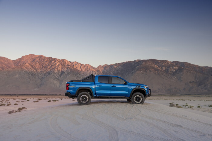 Side view of Colorado ZR2 in desert with mountains in the background.