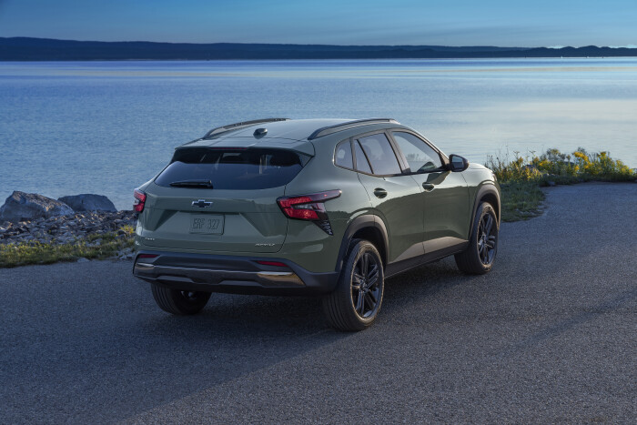 Rear 7/8 view of Chevrolet Trax ACTIV in Cacti Green parked on a road in front of a lake. Pre-produc