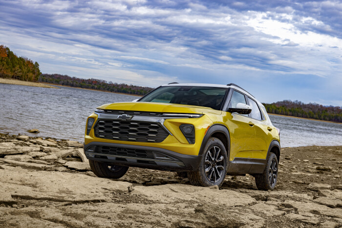 Front 3/4 view of 2024 Chevrolet Trailblazer ACTIV in Nitro Yellow Metallic parked on a rock bank in front of a lake. Preproduction model shown. Actual production model may vary. Available in fall 2023.