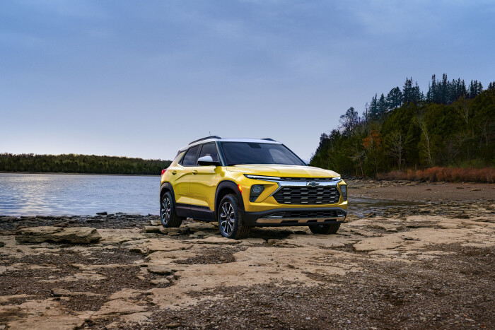 Front 3/4 view of 2024 Chevrolet Trailblazer ACTIV in Nitro Yellow Metallic parked on a rock bank in front of a lake. Preproduction model shown. Actual production model may vary. Available in fall 2023.