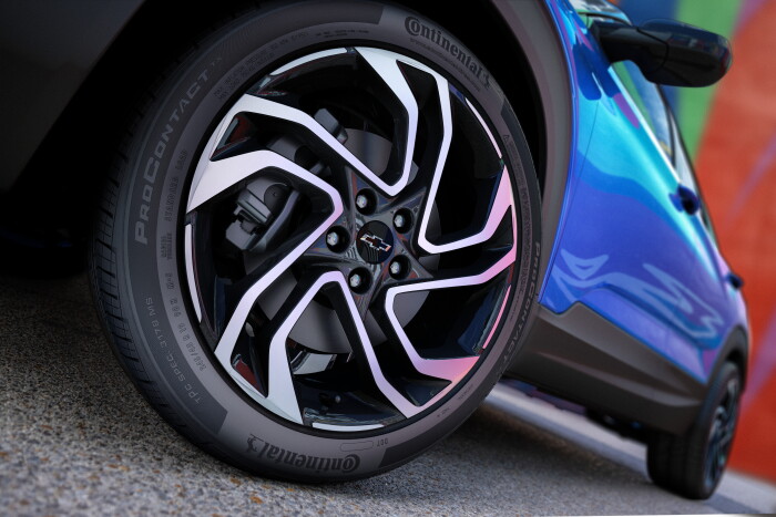 Close up view of drivers side front wheel on 2024 Chevrolet Trailblazer RS in Fountain Blue parked in front of a building. Preproduction model shown. Actual production model may vary. Available in fall 2023.