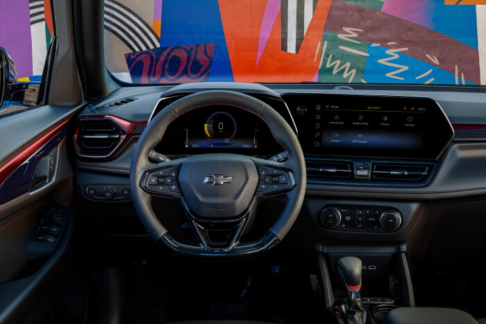 View of steering wheel and infotainment screen in front cabin of 2024 Chevrolet Trailblazer RS with Jet Black with Red Accents interior. Preproduction model shown. Actual production model may vary. Available in fall 2023.