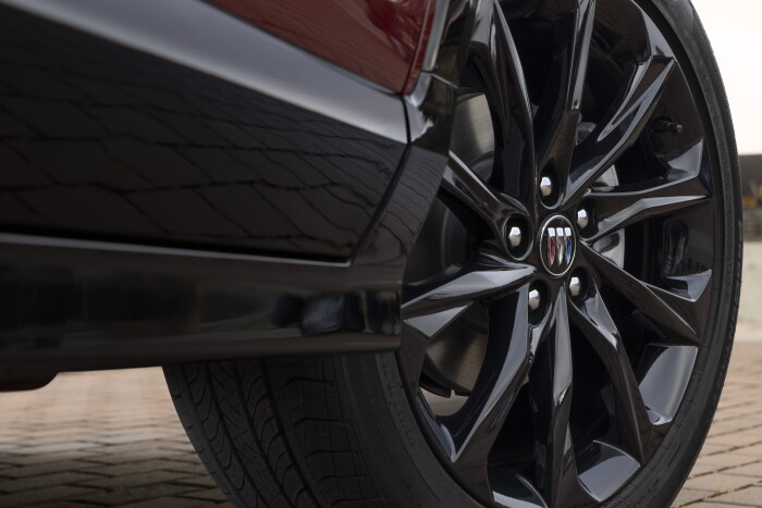 Close up view of the 19-inch all-black wheel on the 2024 Buick Encore GX ST in Cinnabar Metallic. Preproduction model shown. Actual production model may vary. Available in Spring 2023.