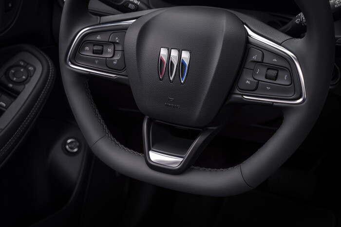 Close up view of the flat-bottom steering wheel cabin in the 2024 Buick Encore GX ST with Jet Black interior. Preproduction model shown. Actual production model may vary. Available in Spring 2023.