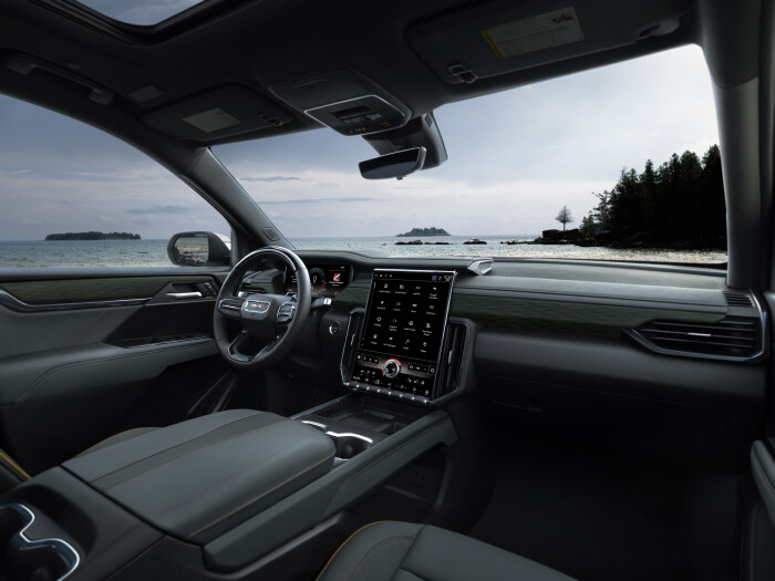 View of AT4 interior featuring the all-new 2024 GMC Acadia dashboard with 15-inch portrait-oriented screen, 11-inch driver information cluster and Super Cruise equipped steering wheel.